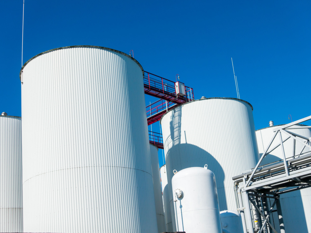 Serbatoi cilindrici bianchi per stoccaggio e trattamento rifiuti liquidi industriali in impianto Ecoindustria.