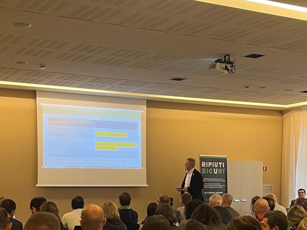 Formazione Ecoindustria: Fabio Tamassia spiega normativa sui rifiuti a imprenditori in aula conferenze.